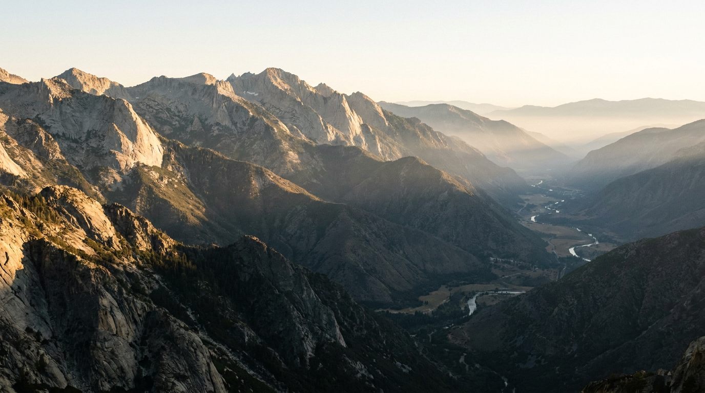 First light spreading across a high Sierra ridgeline above the country below, a clear long view from high ground